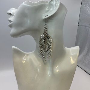 Stunning multi layered silver tone earrings faux diamond center.